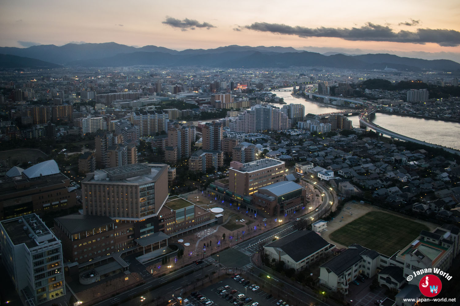 Vue sur les quartiers de Fukuoka et les montagnes à la tombée du jour